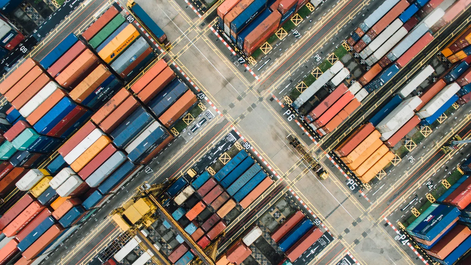 An aerial view of stacked shipping containers at a port