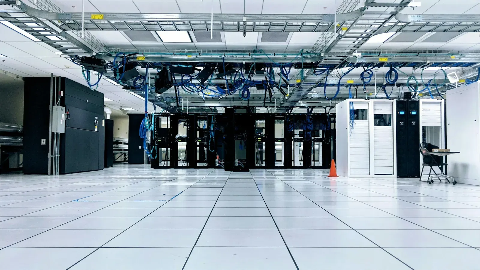 Rows of server cabinets in a data centre, lit in blue