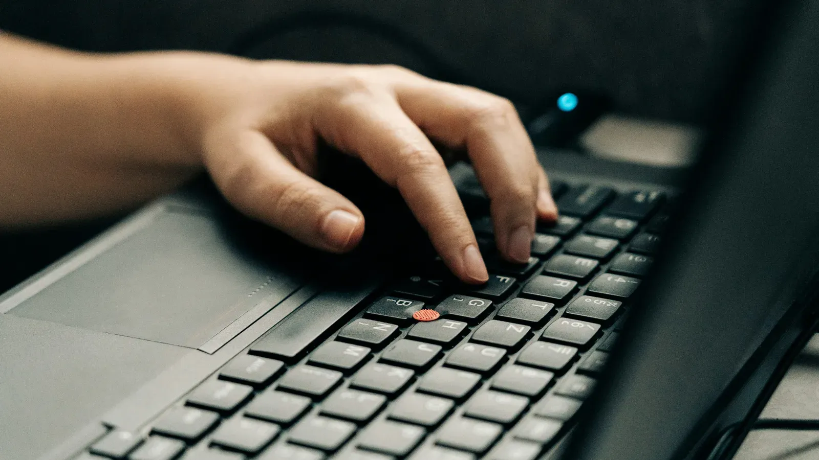 A hand typing on a laptop keyboard, seen close up